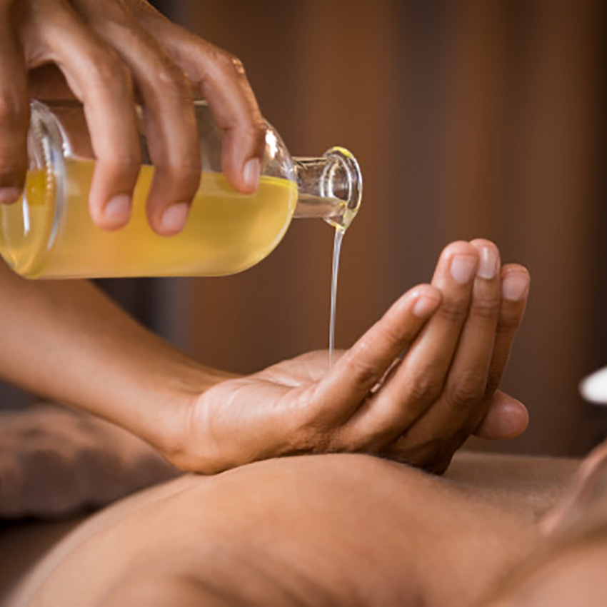 Aromatherapy oil being poured near candles